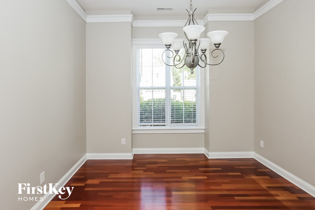 an empty room with a window and a chandelier