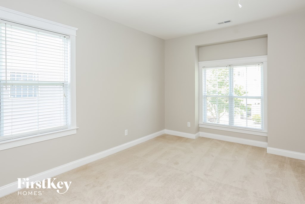 a clean and empty room with two windows