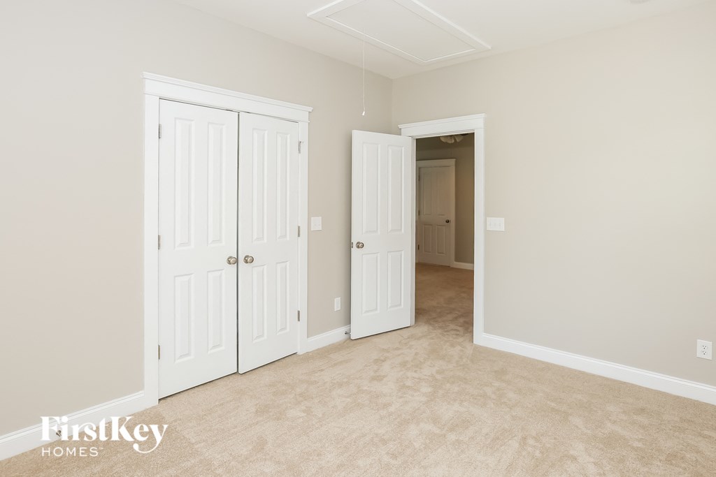 a bedroom with two closets and a door to a hallway