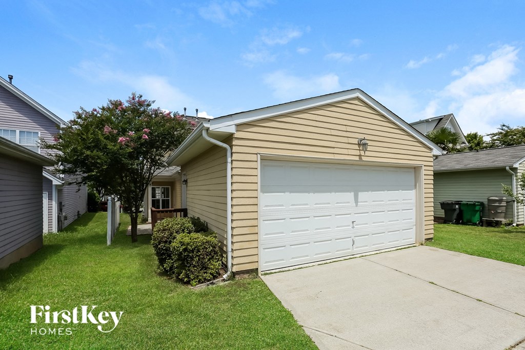 a small tan house with a white garage door