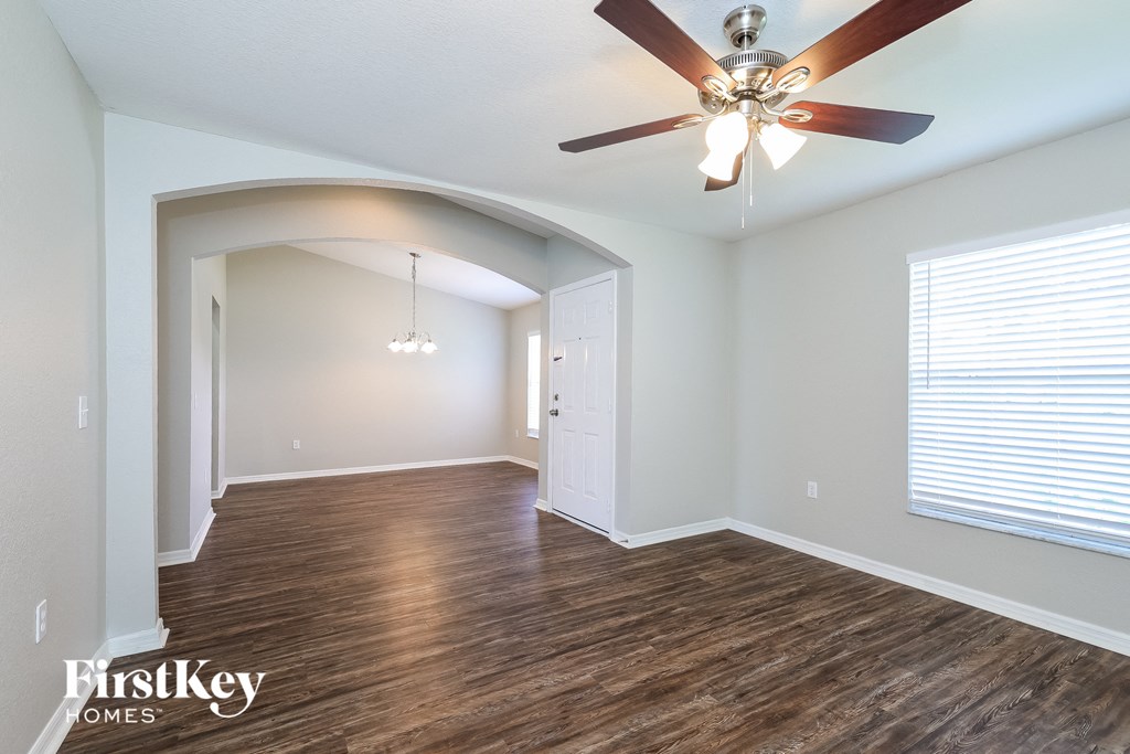 a living room with wood floors and a ceiling fan