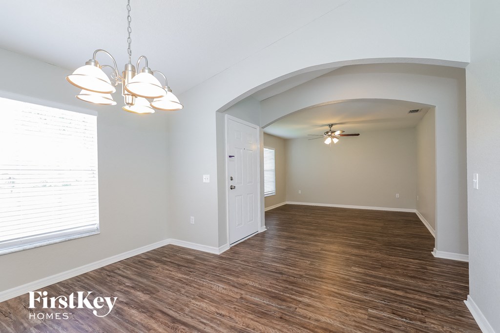 the living room and dining room with wood flooring and a large window