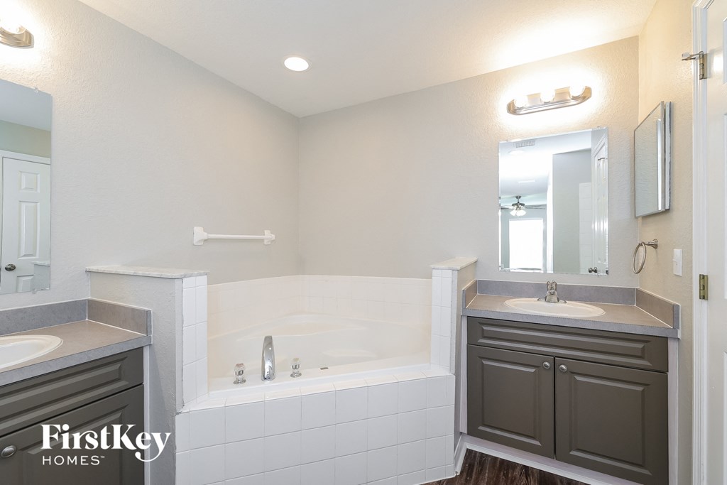 a bathroom with a tub and a sink and a mirror
