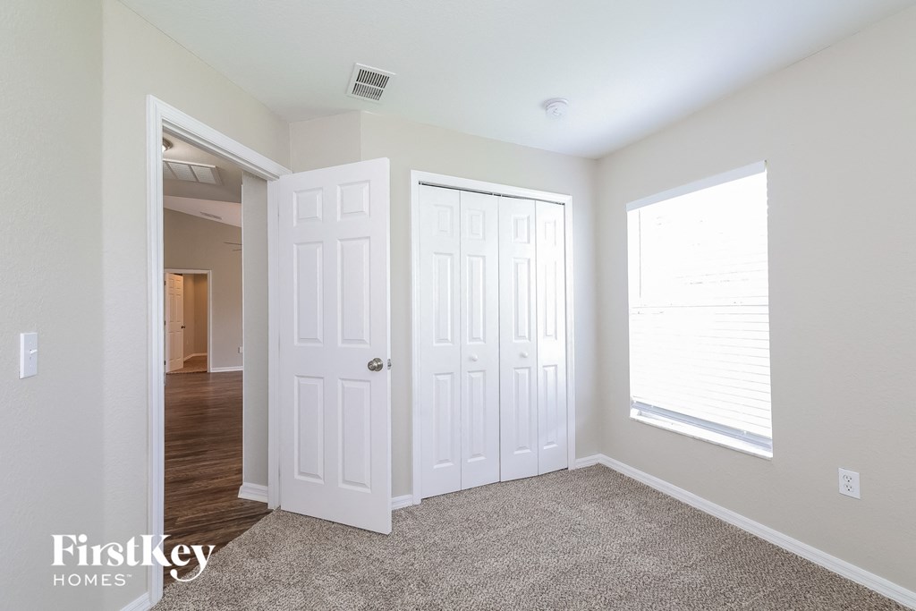 a bedroom with two closets and a door to a hallway