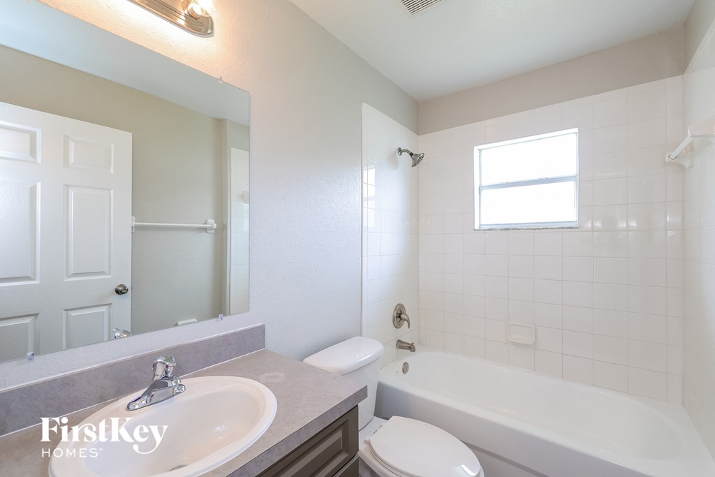 a bathroom with a tub sink and toilet and a mirror