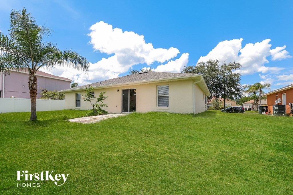 a home with a lawn and a palm tree