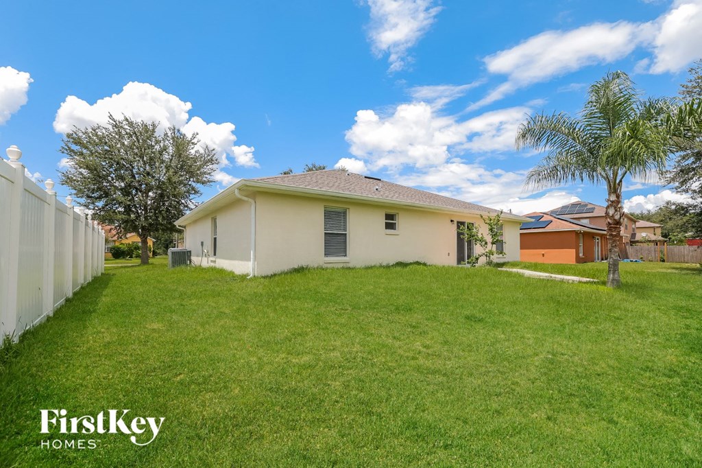 a backyard with a house and a palm tree