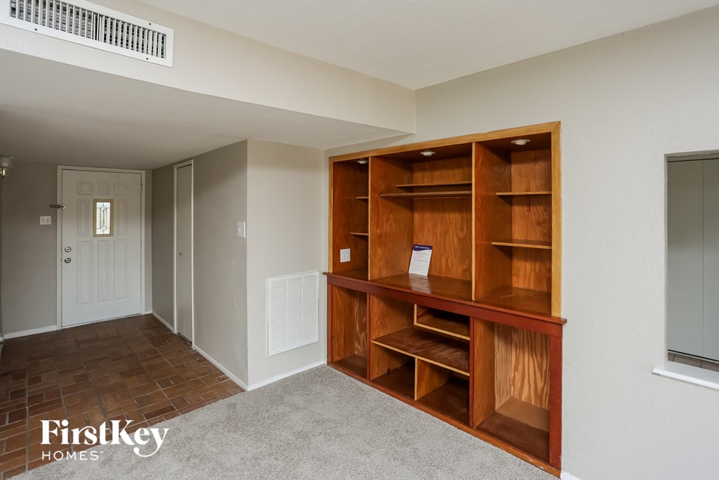 a book shelf in a room with a hallway and a door