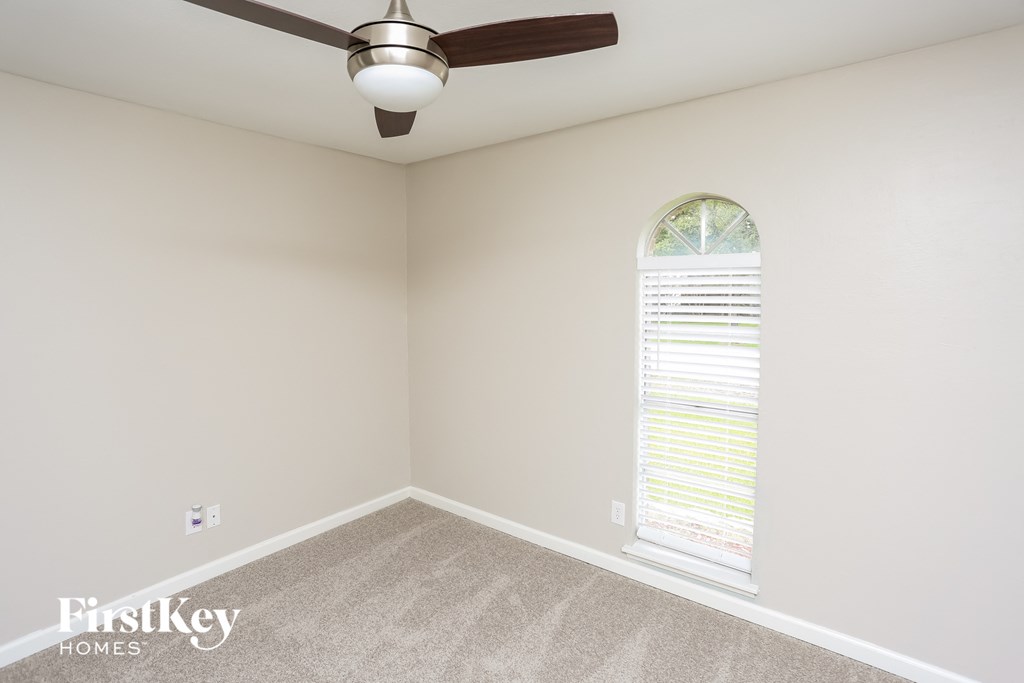 a bedroom with a ceiling fan and a window