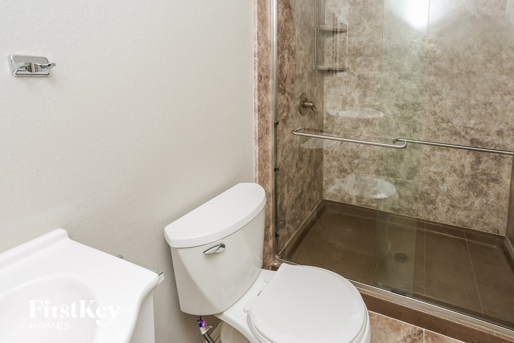 a bathroom with a toilet and a shower