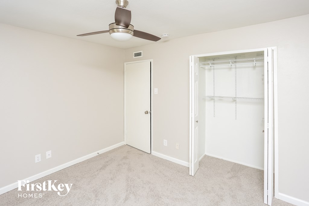 a bedroom with a closet and a ceiling fan