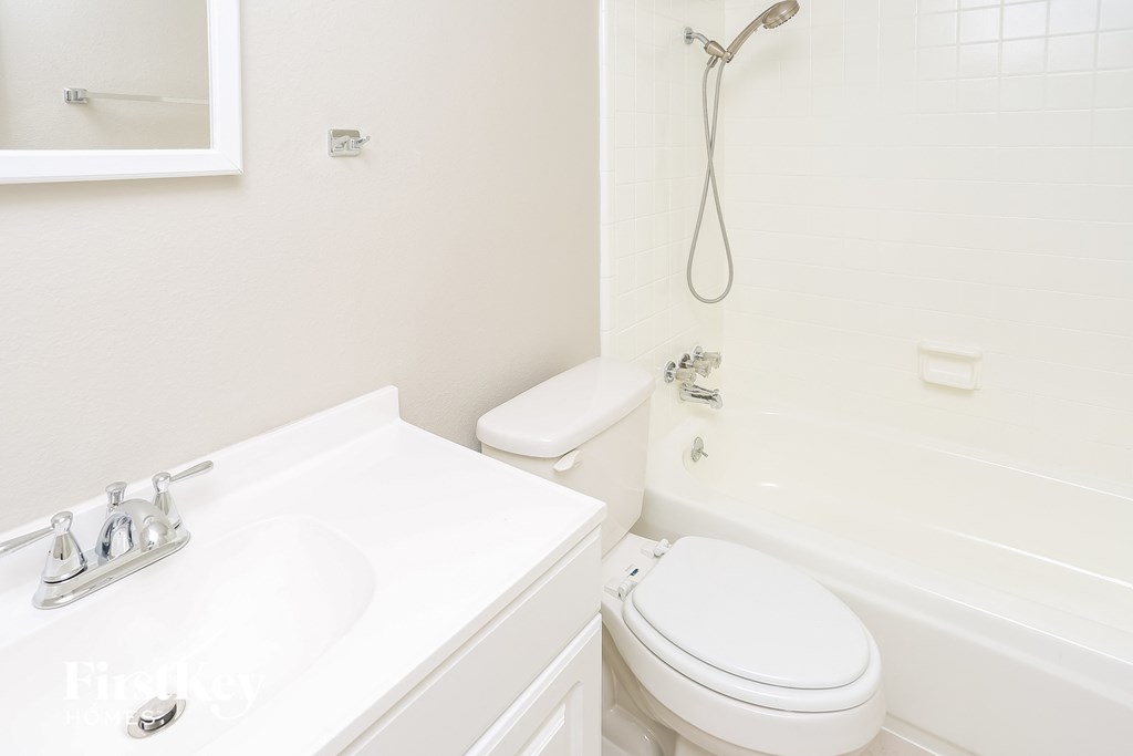 a white bathroom with a toilet and a tub and a sink