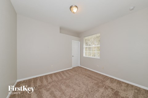 the living room of a home with carpet and a window