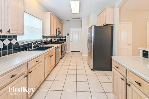 a kitchen with wooden cabinets and a stainless steel refrigerator