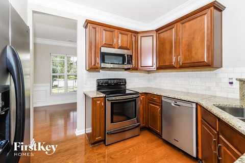 A kitchen with wooden cabinets and a stainless steel refrigerator.