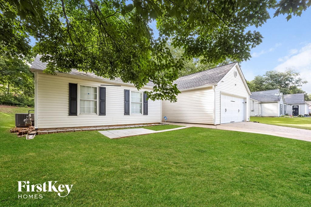 A house with a lawn and trees in the background.