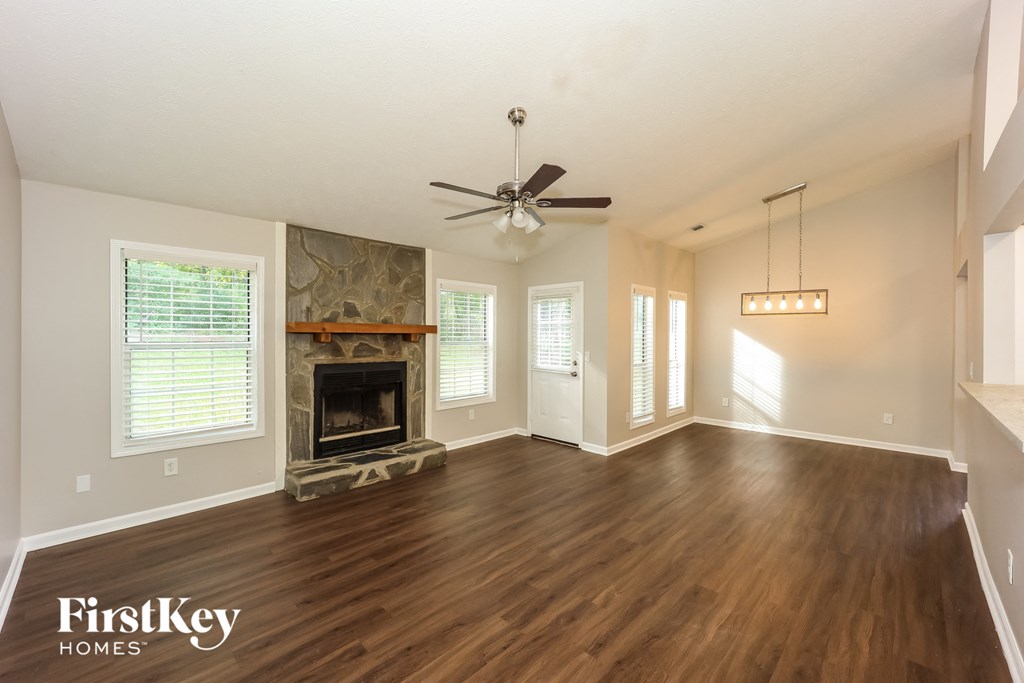 A spacious living room with wood flooring and a fireplace.