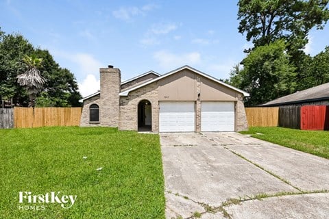 a brick house with a white garage door and a lawn