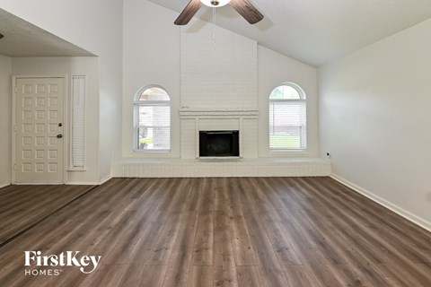 the living room of an empty house with a fireplace