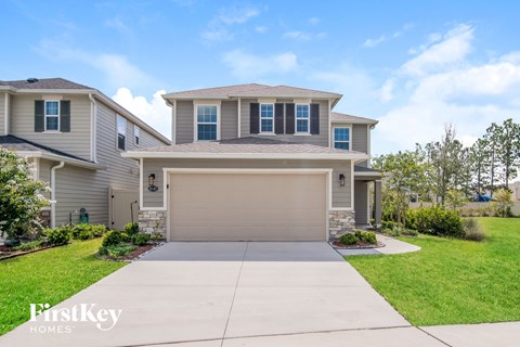 a beige house with a garage door and a driveway