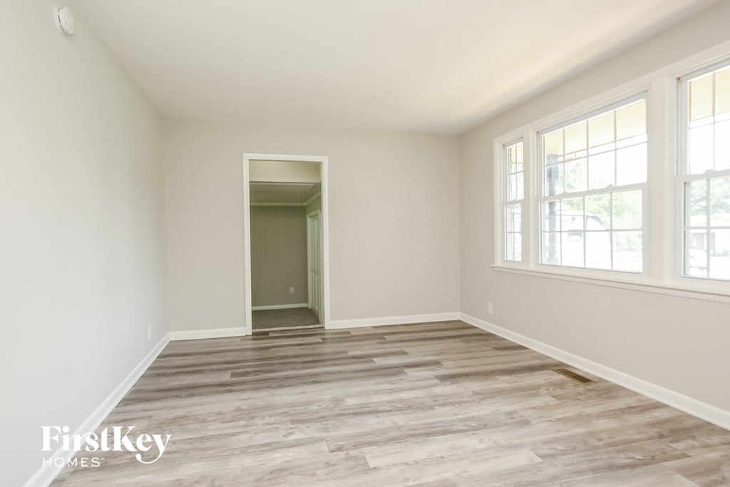 A room with wooden flooring and a doorway leading to another room.