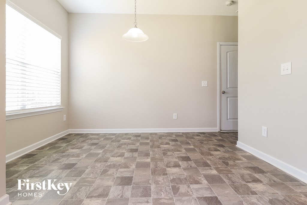 an empty room with tile flooring and a white door