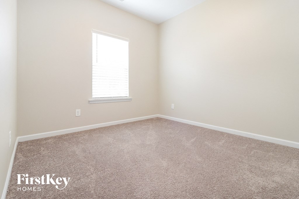 an empty room with carpet and a window
