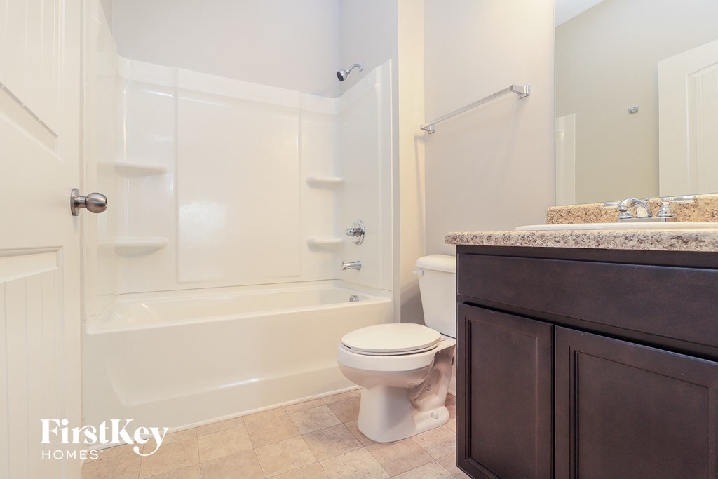 a bathroom with a toilet and a tub and a sink