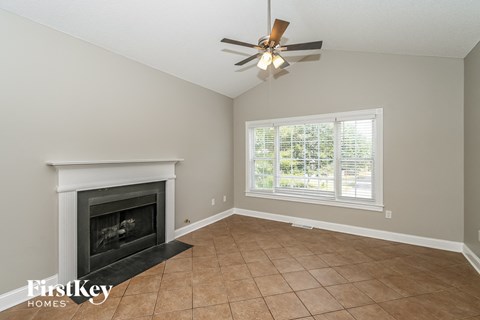 a living room with a fireplace and a ceiling fan