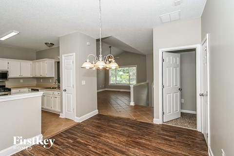 a kitchen and dining room with white cabinets and a wood floor