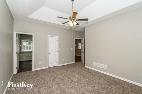 a living room with carpet and a ceiling fan