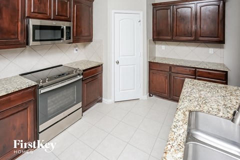 A kitchen with brown cabinets and a stainless steel oven.