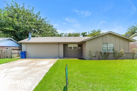 A house with a garage and a green lawn.