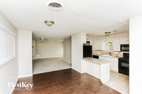 A kitchen with a white island and black appliances.