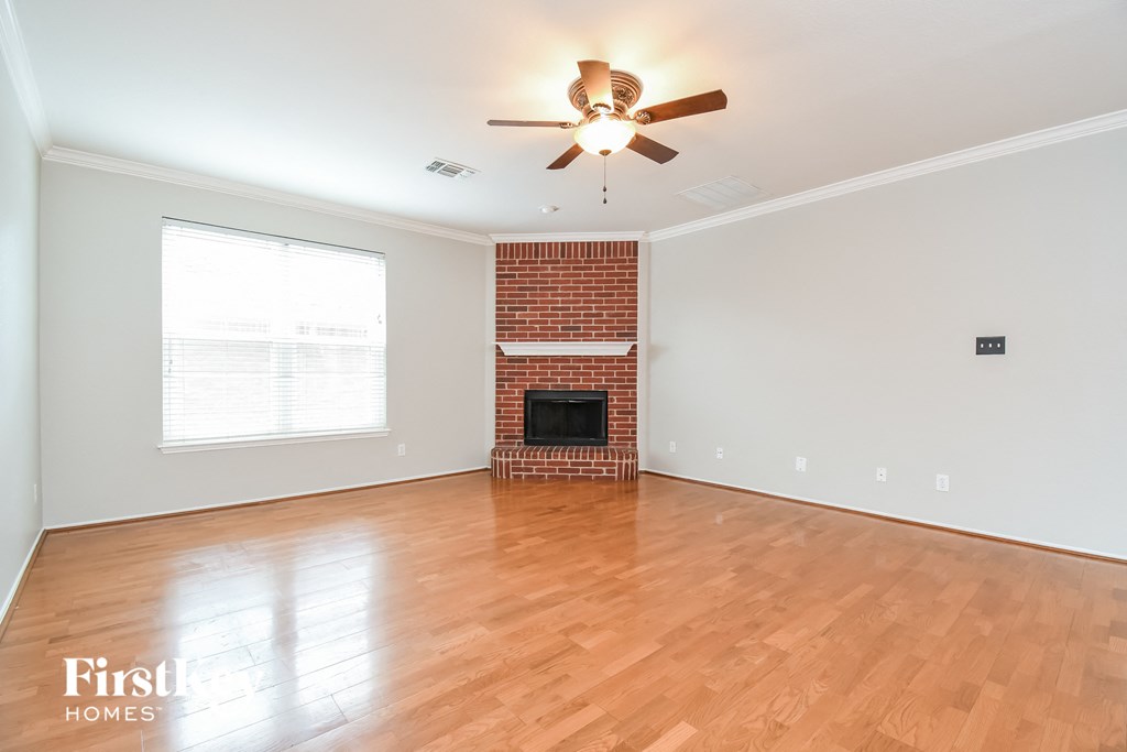 a living room with a fireplace and a ceiling fan