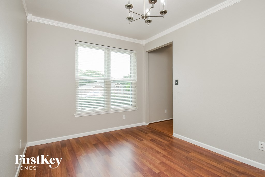 the living room with hardwood floors and a large window