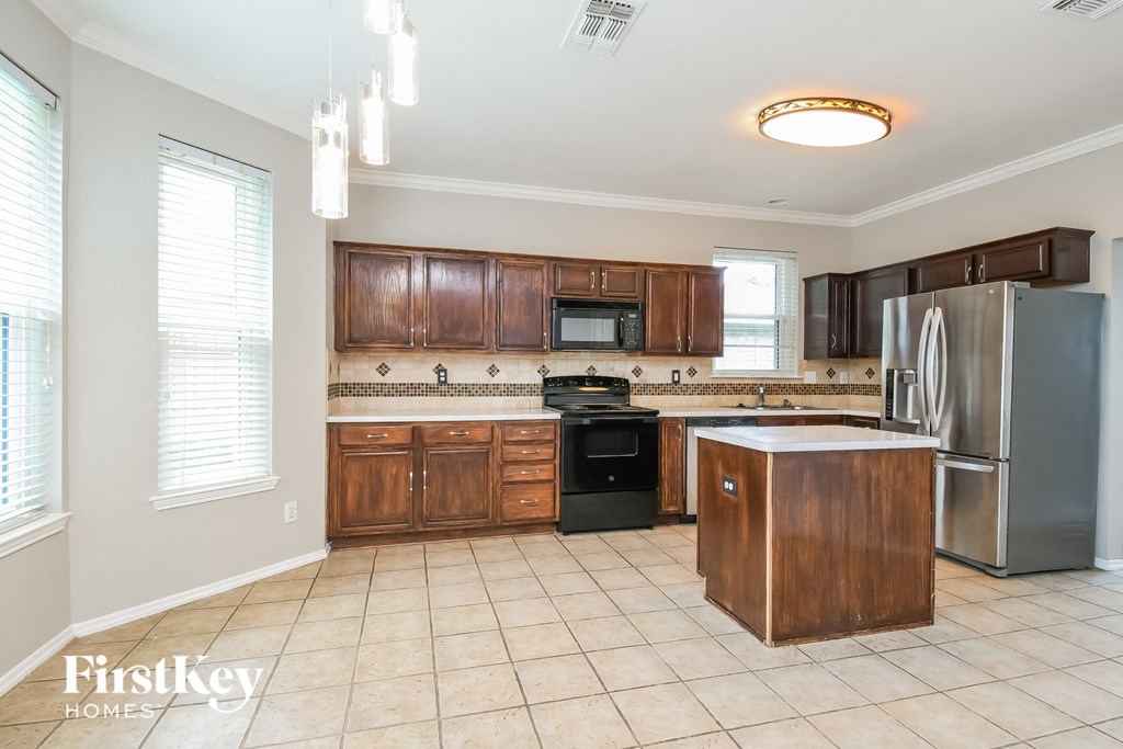 a kitchen with wooden cabinets and stainless steel appliances