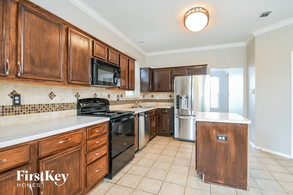 a kitchen with wooden cabinets and stainless steel appliances