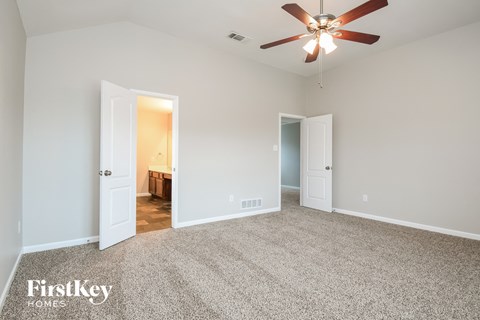 a living room with carpet and a ceiling fan