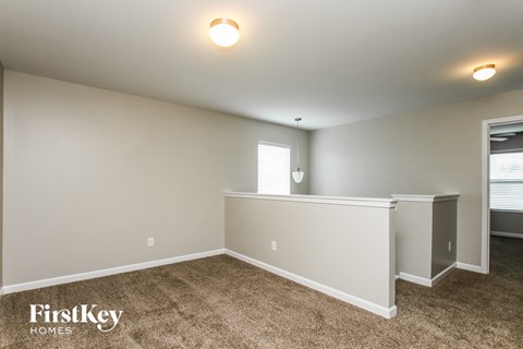 the living room and dining room with carpeted floors and white walls