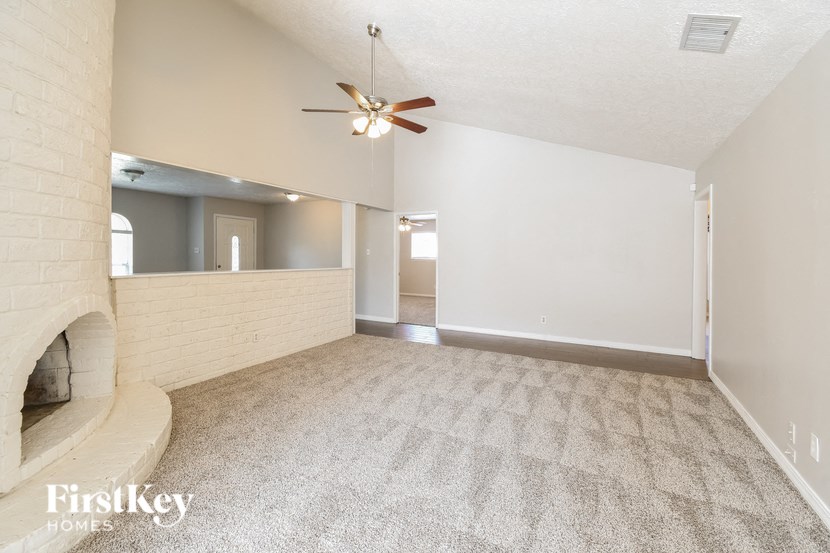 A spacious room with a fan and a fireplace.