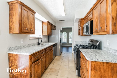 A kitchen with wooden cabinets and granite countertops.
