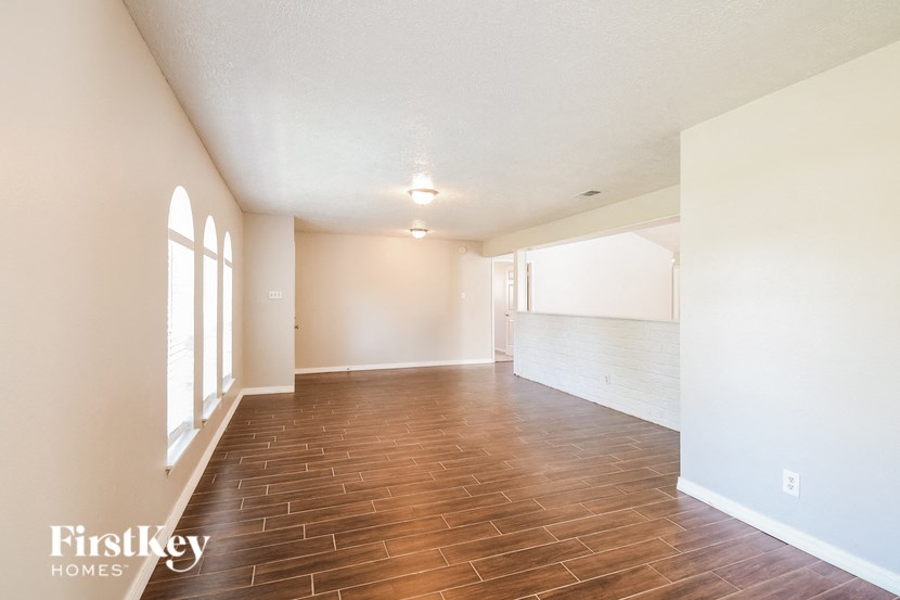 A room with wooden flooring and white walls.