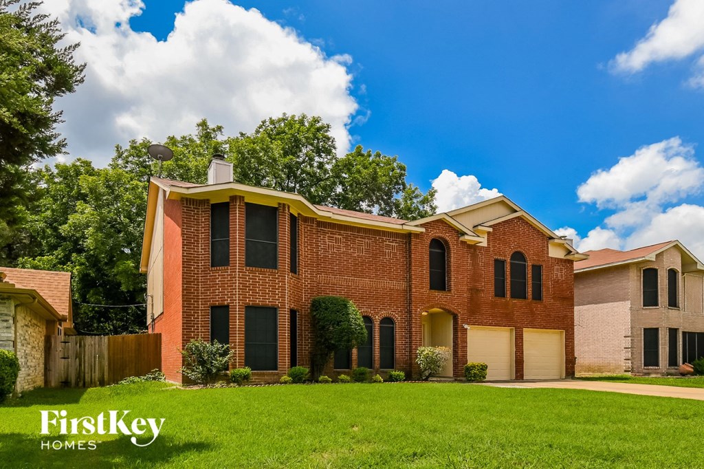 a large brick house with a lawn in front of it