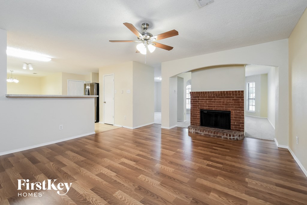 a living room with a fireplace and a ceiling fan