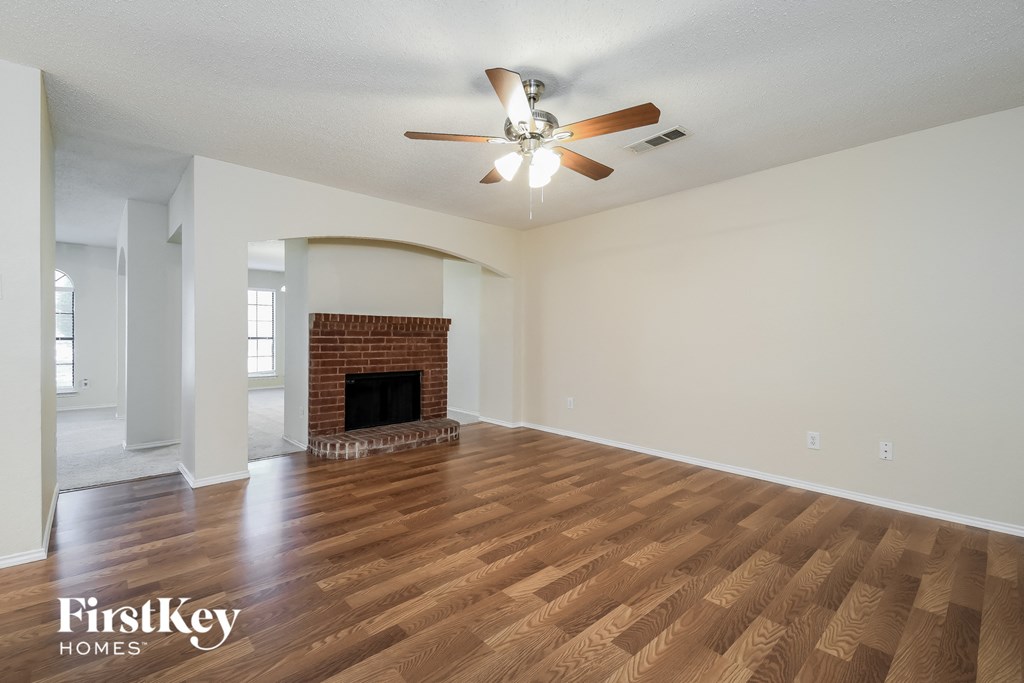 a living room with a fireplace and a ceiling fan
