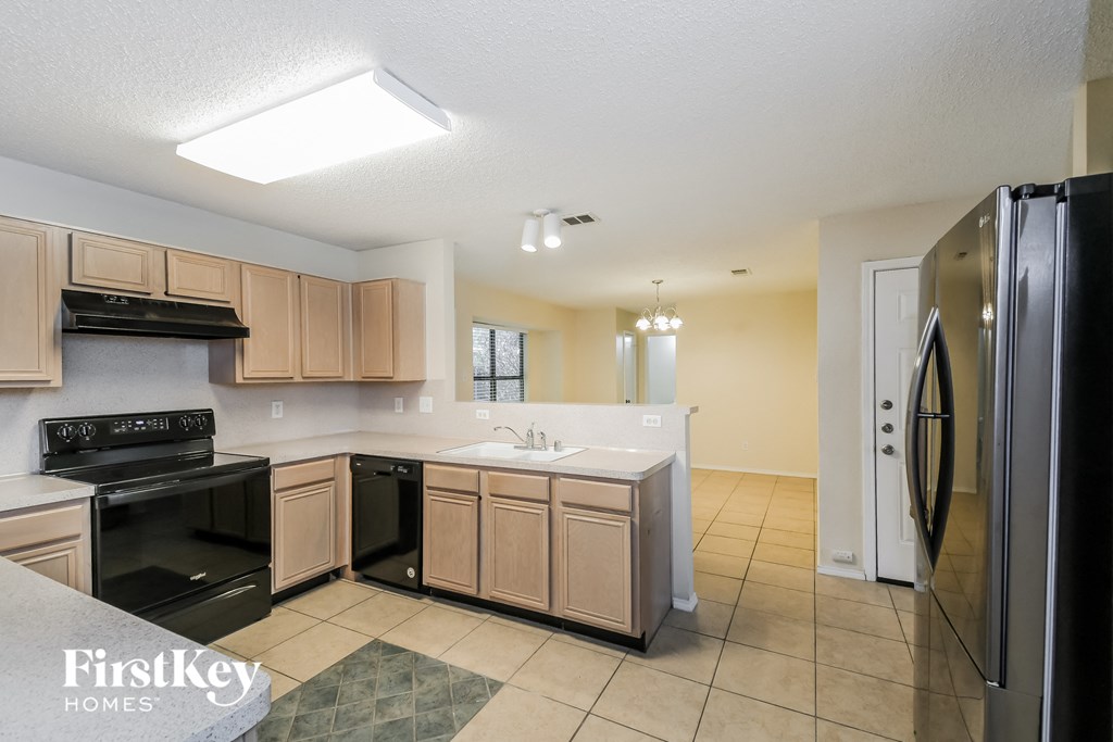 a kitchen with black appliances and wooden cabinets