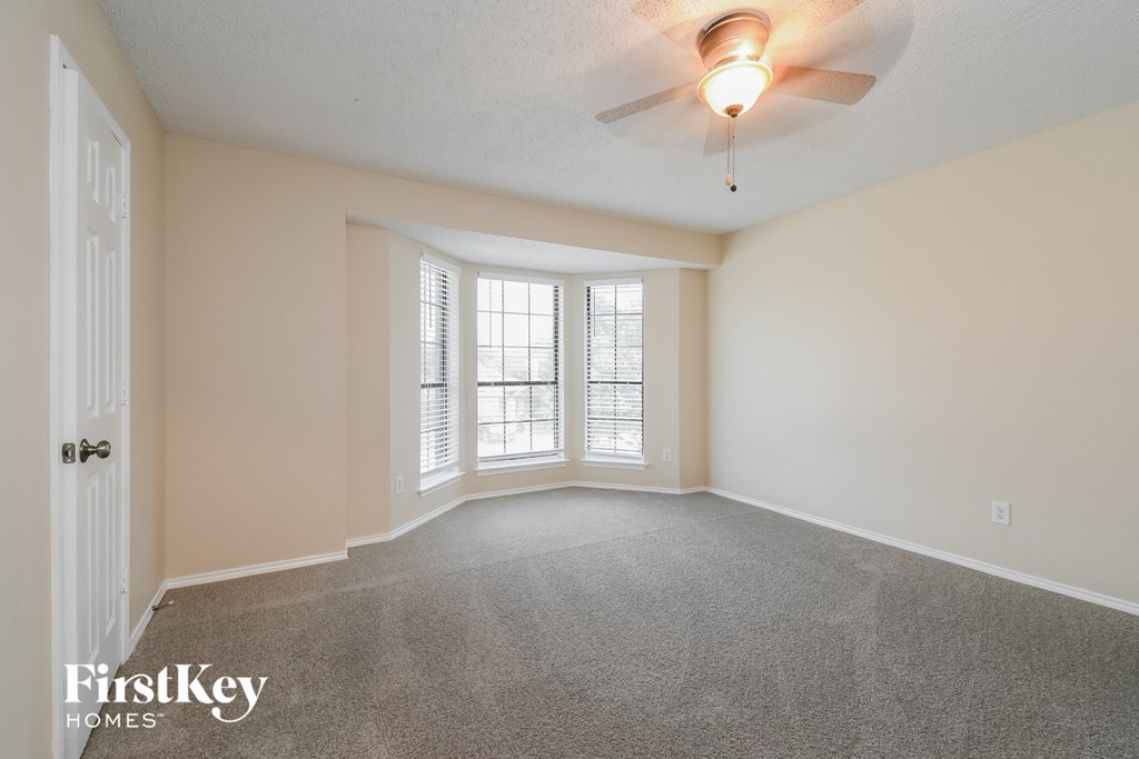 the living room of an empty house with a ceiling fan