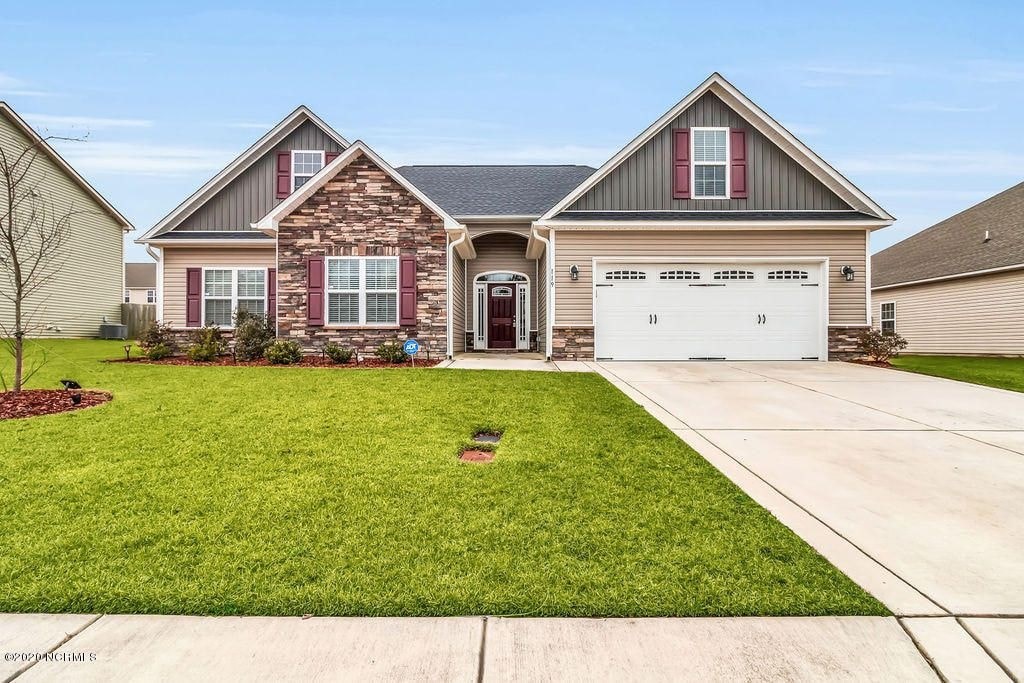 A house with a red brick facade and a white garage door.