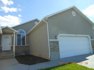 A house with a white garage door and a stone pillar.
